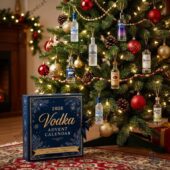 2026 Vodka Advent Calendar box displayed next to a decorated Christmas tree with miniature liquor bottle ornaments.