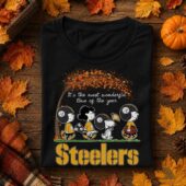Steelers It's The Most Wonderful Time Of The Year Shirt 3 Peanuts characters wearing Pittsburgh Steelers gear on a black t-shirt surrounded by fall leaves.