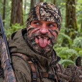 Man wearing a camouflage hunting balaclava in a forest setting