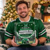 Man holding a Marshall Thundering Herd advent calendar in front of a Christmas tree