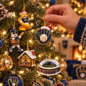 Hand hanging Milwaukee Brewers baseball themed holiday ornaments on a Christmas tree