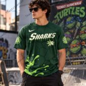 Man wearing a green Teenage Mutant Ninja Turtles and Sharks themed t-shirt
